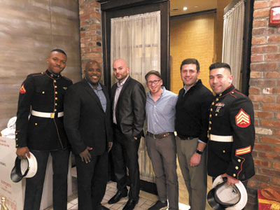 U.S. Marines attend to collect donations at the MACC NY holiday party