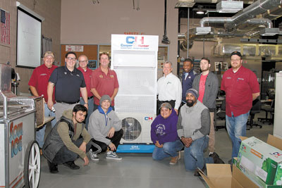 Edwin Velez (in black shirt on left) and Tod Sutherland (in white shirt next to display) of Tropic Supply with some Daytona State College AC students and a donated C&H system.