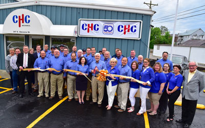 The staff at CHC Mechanical cuts their 50th Anniversary Gold Ribbon to celebrate together.