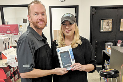 Daytona Beach Lennox Store Manager Cody Keith with tablet raffle winner Tracie Young of ECO Air Systems.