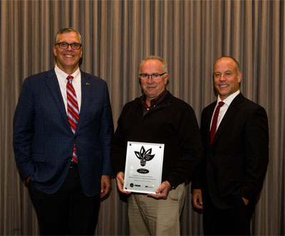 Donny Simmons, president, Trane Commercial HVAC North America, Europe, Middle East and Africa, left, presents Dwayne Atkins, engineering manager, Ford Motor Company, middle, Trane’s Energy Efficiency Leader Award, alongside Parry Hughes, VP & general manager, Trane Michigan, right.