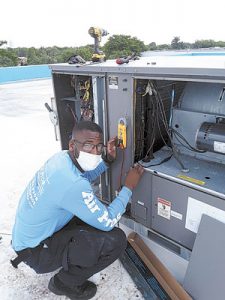 An Air Pros USA Technician installing a Fresh-Aire UV unit at a BGCBC location in Hollywood, FL