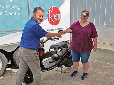 Panama City Sales Center Manager Tony John presents the Rheem-sponsored Honda Ruckus to Grand Prize winner Terri Bird of Metcalf Electric and Air