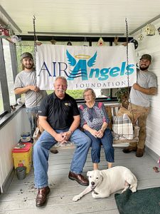 Jim Jones of Tropic Aire seated with Joan Moore as Tropic Aire team members Dustyn Hardwick and Michael Crawford hold the Air Angels banner